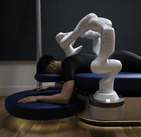 The Aescape robotic massage table with its two arms positioned over a person's back.